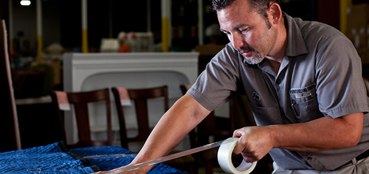 Furnitureland South employee protecting a piece of furniture before delivery