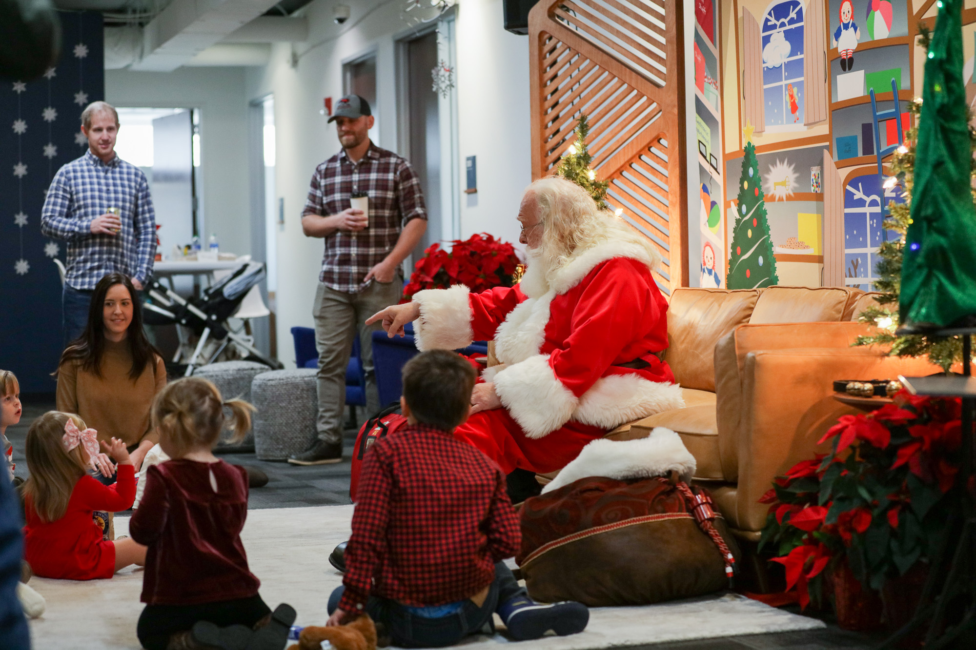 Santa Claus pointing to a child sitting on the floor