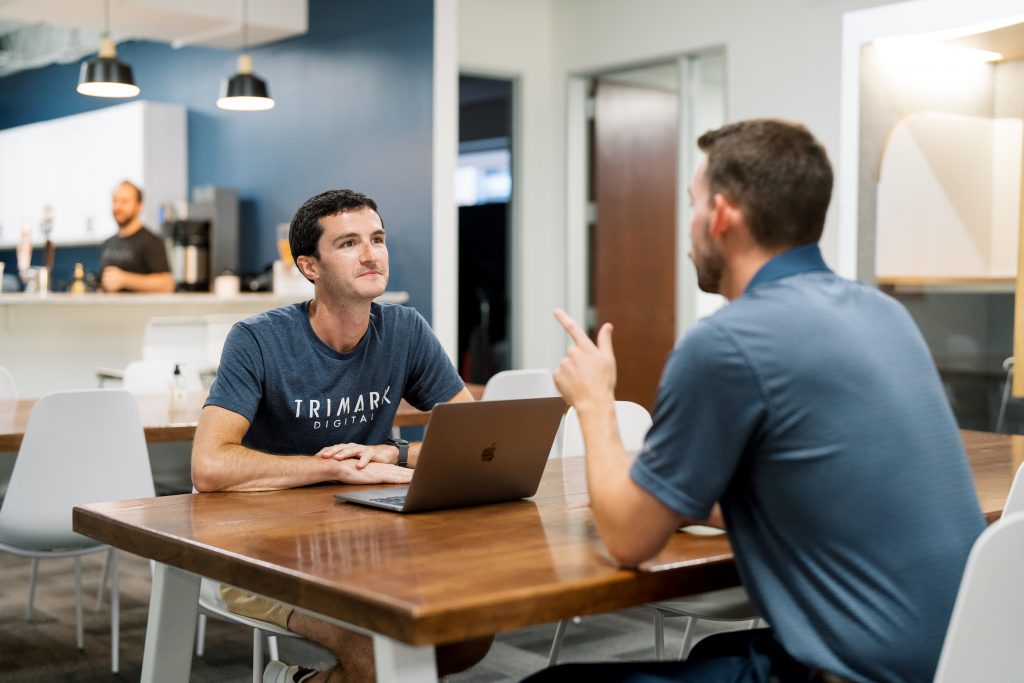 Two men having a conversation at a kitchen table