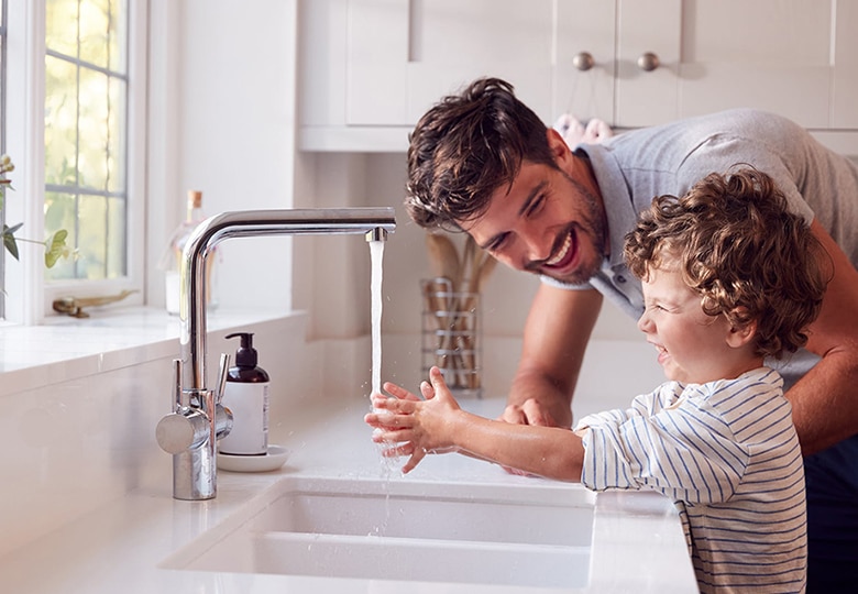 Dad and son washing hands in the sink
